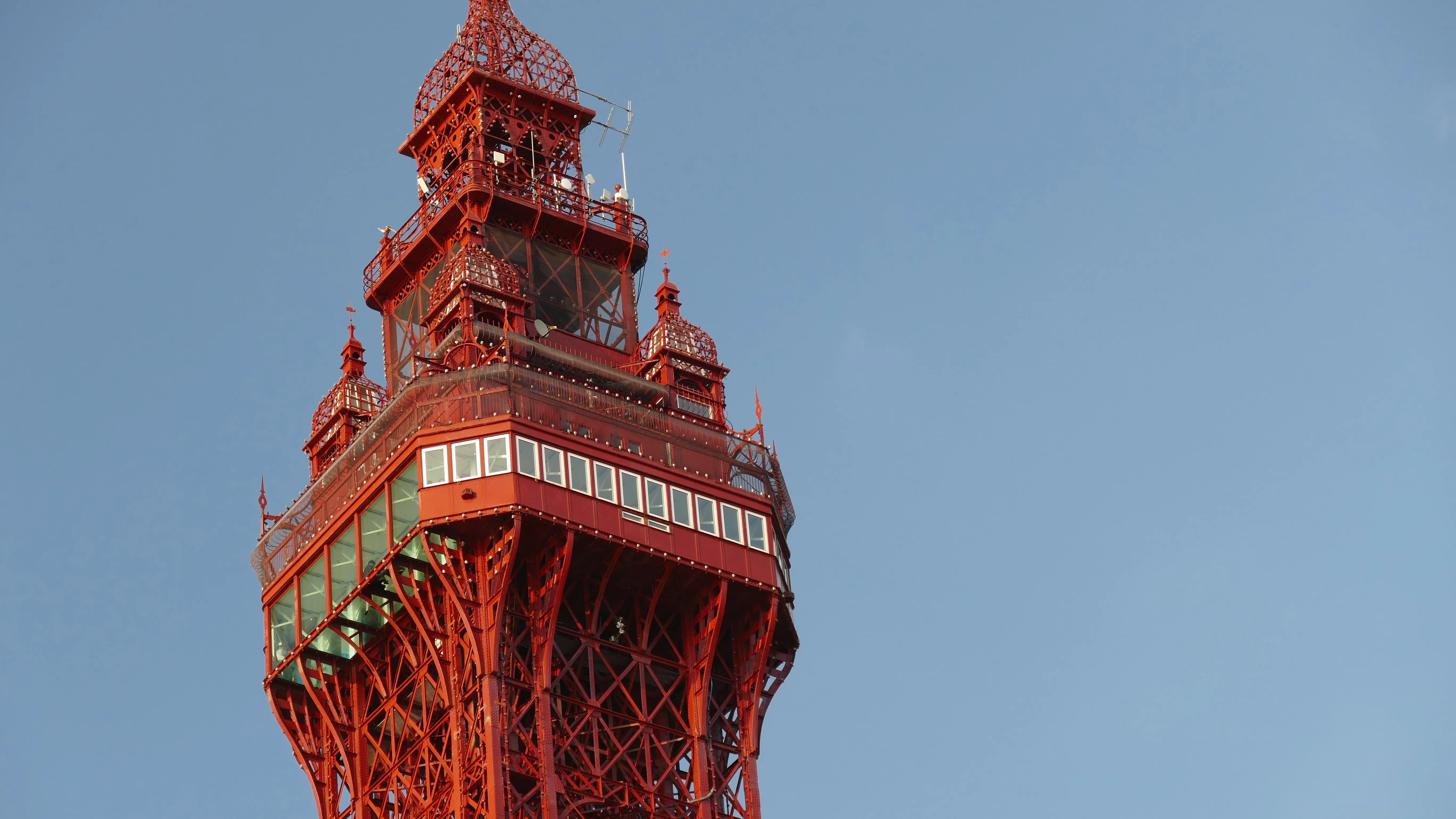 A close-up of the top portion of Blackpool Tower with its red metalwork