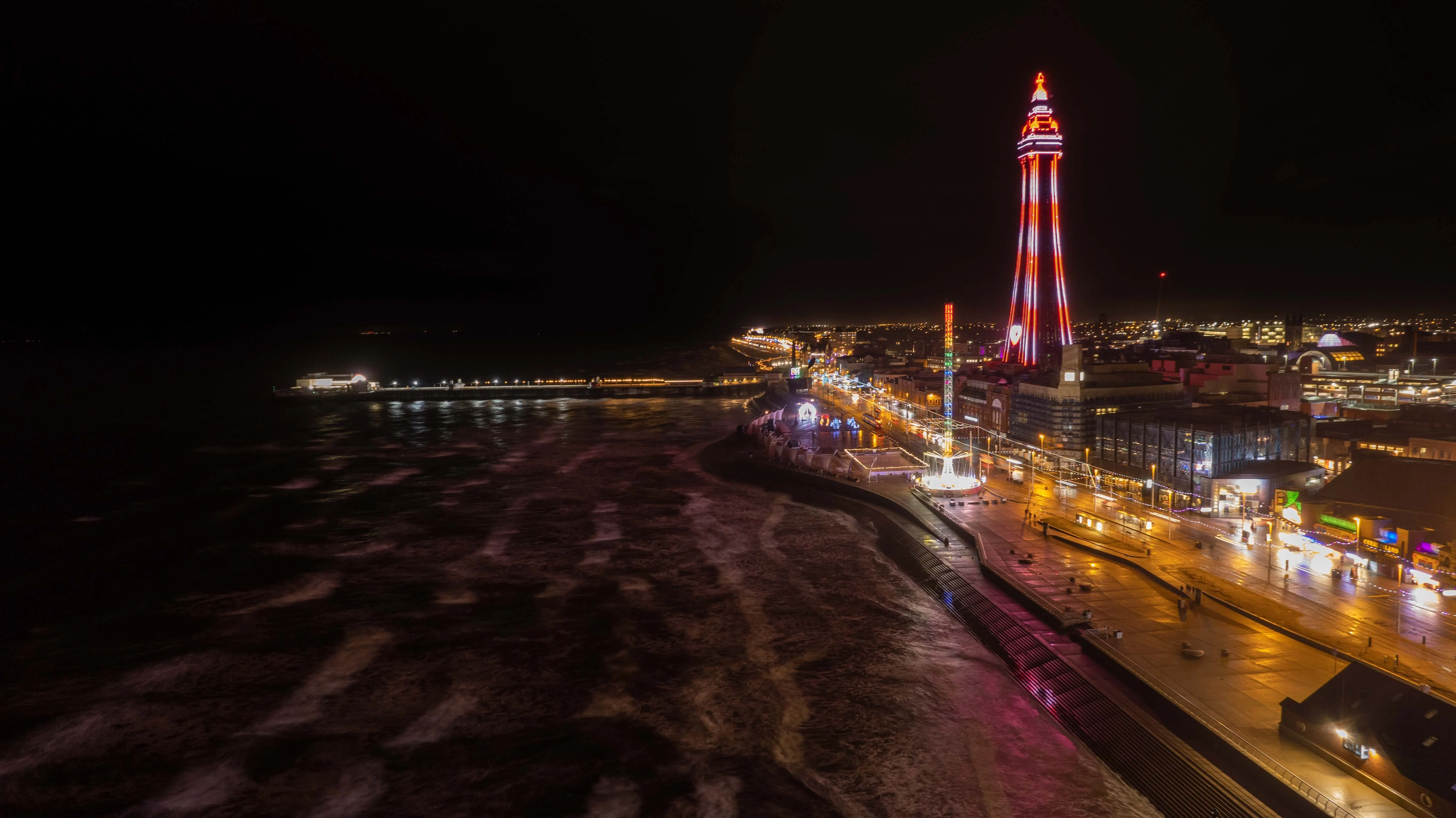 Blackpool Tower, the promenade and the sea illuminated at night